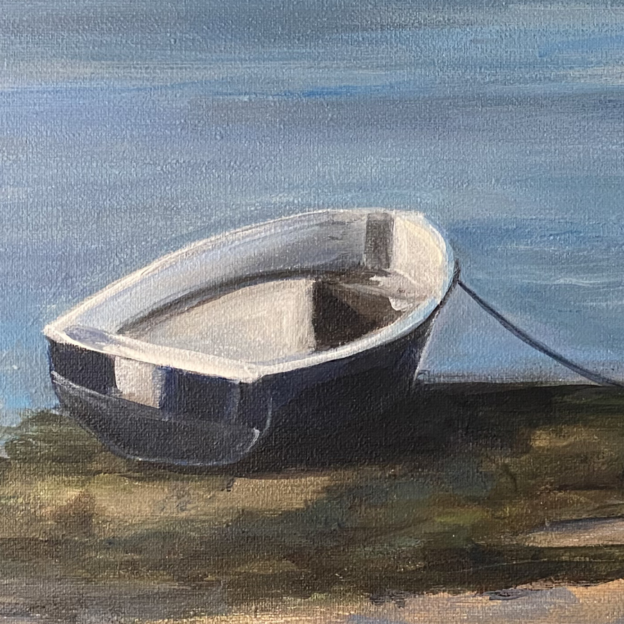 Beach scene of a little row boat tied up in the foreground. It&rsquo;s a lovely, sunny day and there is a coast line with some buildings and low hills in the background.