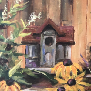 Little birdhouse set amid flowers in a garden. There is a fence in the background, while black-eyed susans, lavender and white hydrangea.