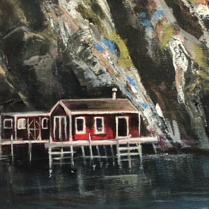Small shacks near large colourful cliffs at Quidi Vidi Village in Newfoundland.