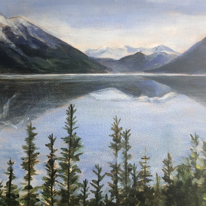 Majestic purple mountains in the background are reflected in a  large body of water. Pine trees are lined up across the foreground.
